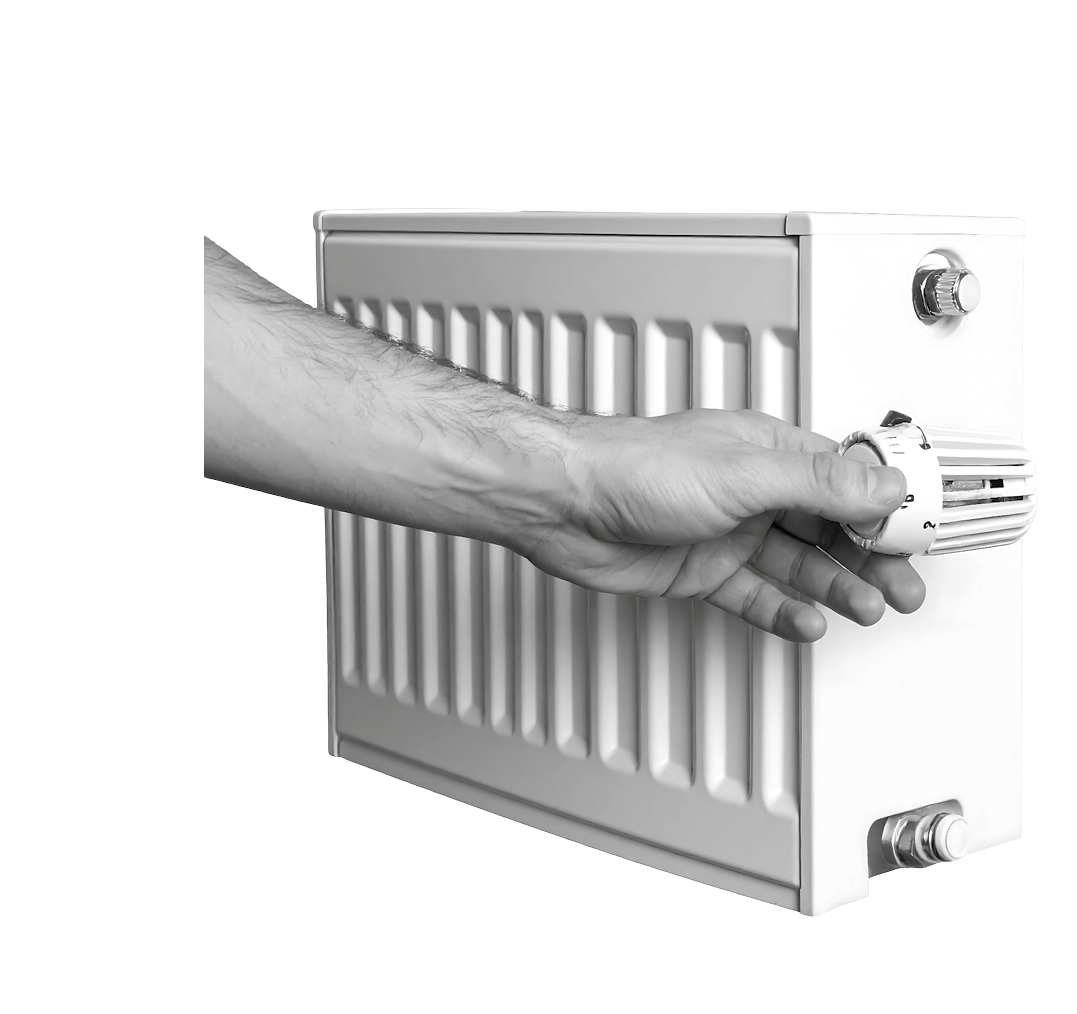 A person's hand turning the temperature control knob on a modern, white, panel radiator against a dark background